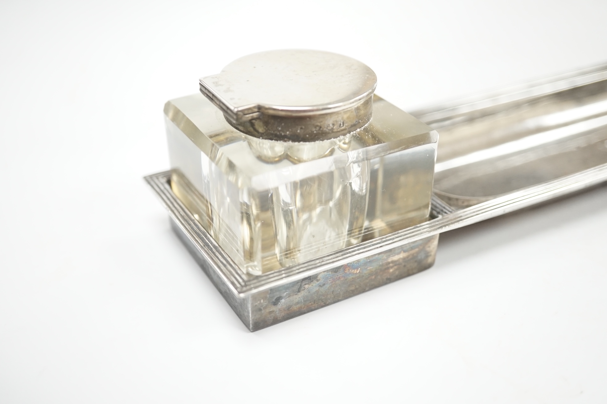 A George V silver rectangular inkstand, with two mounted glass wells and pen recess, John Grinsell & Sons, Birmingham, 1910, length 35.4cm, stand 7.2oz. Condition - fair to good